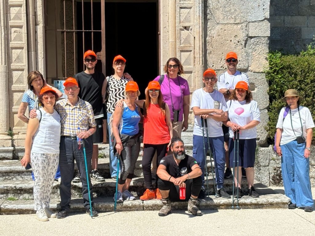 Il gruppo con i cappellini arancioni sui gradini di una chiesa