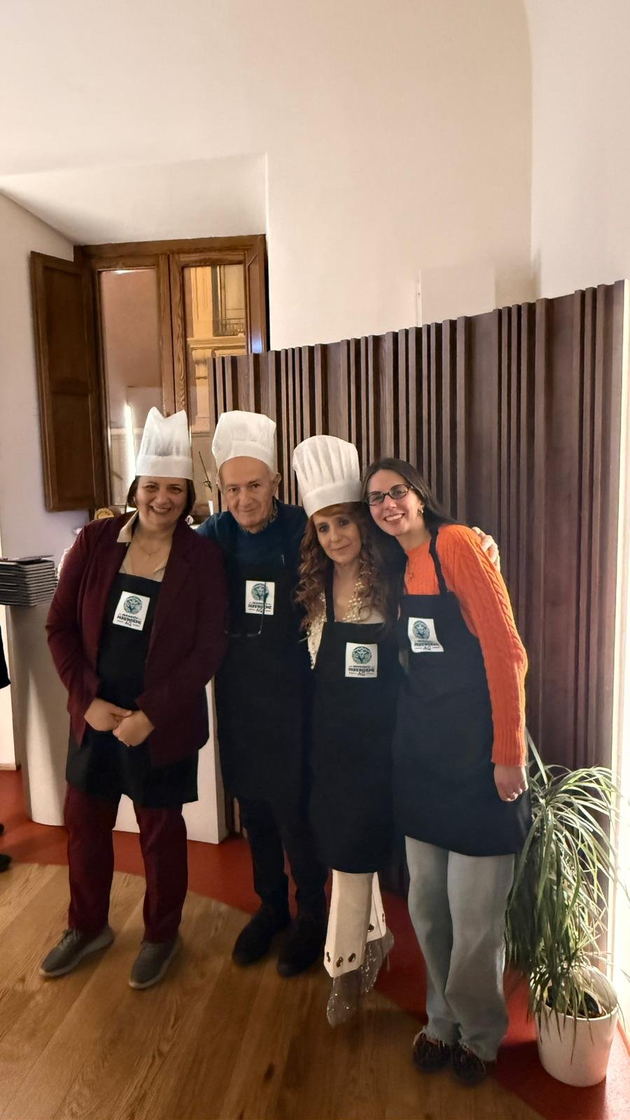 Foto di gruppo dei partecipanti in grembiule e cappello da cuoco